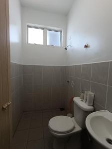 a bathroom with a toilet and a sink and a window at Khayla Homestay in Kuah