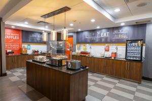 a fast food restaurant with a counter with food at Hampton Inn & Suites Greensboro/Coliseum Area in Greensboro