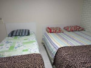 two beds sitting next to each other in a room at Praia de Geribá e piscina para sua família! in Búzios +45 photos