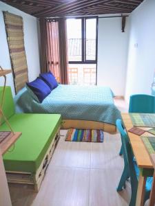 Un dormitorio con una cama y una mesa y sillas. en Downtown, Blue Green Home, Nature inspired, en Bogotá 41 fotos más