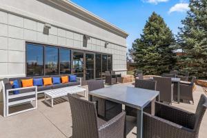 un patio con banco, mesa y sillas en Hampton Inn & Suites Greeley, en Greeley