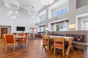 a dining room with tables and chairs and windows at Hampton Inn & Suites Greeley in Greeley