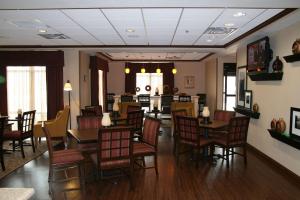 una sala da pranzo con tavoli e sedie in legno di Hampton Inn Gallipolis a Gallipolis