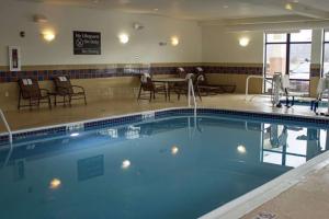 a swimming pool in a hotel with chairs and tables at Hampton Inn Gallipolis in Gallipolis