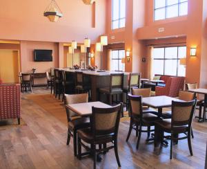 a restaurant with tables and chairs and a bar at Hampton Inn & Suites Green River in Green River