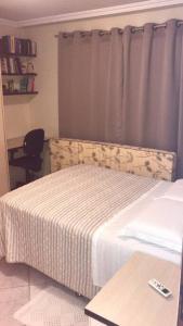 a bedroom with a bed and a window with a curtain at Casa próximo ao Boticário in São José dos Pinhais