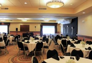 um salão de banquetes com mesas e cadeiras brancas em Hampton Inn & Suites Green River em Green River