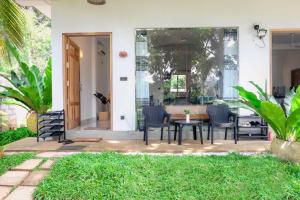 a patio with chairs and a table in a house at Villa River Edge in Weligama