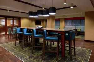 a large kitchen with a bar with blue chairs at Hampton Inn Greensboro Airport in Greensboro