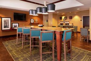 a large kitchen with a large island with blue bar stools at Hampton Inn Greensboro Airport in Greensboro