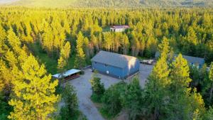 an aerial view of a barn in the middle of a forest at Pinetree Lodge: Hot Tub Fire Pit in Athol