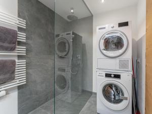 a bathroom with a washing machine and a washer and dryer at Tauernsuites Uttendorf by Mimi in Uttendorf
