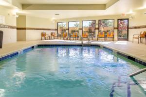 a pool in a hotel room with chairs and tables at Courtyard by Marriott Lexington Keeneland/Airport in Lexington