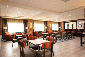 a dining room with tables and chairs and windows at Hampton Inn Hammond in Hammond
