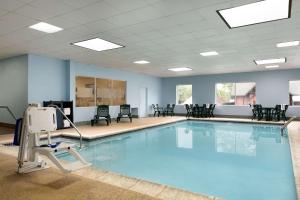 - une piscine avec des chaises et une table ainsi qu'une chambre dans l'établissement Hampton Inn & Suites Hershey, à Hershey