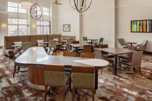 a dining room with tables and chairs and windows at Homewood Suites by Hilton Hartford-Farmington in Farmington