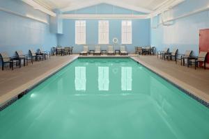 a swimming pool with chairs and tables in a room at Homewood Suites by Hilton Hartford-Farmington in Farmington