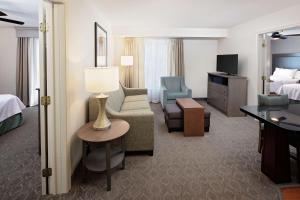 Habitación de hotel con cama y sala de estar. en Homewood Suites by Hilton Hartford-Farmington en Farmington