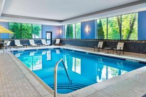 a pool in a hotel lobby with chairs and tables at Hampton Inn and Suites Hartford/Farmington in Farmington