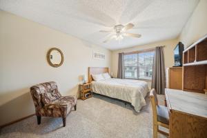ein Schlafzimmer mit einem Bett, einem Stuhl und einem Fenster in der Unterkunft 2-Bedroom Loft Suite 14 minutes from Airport and Mall of America in Inver Grove Heights
