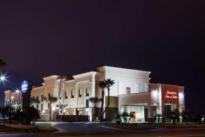 un gran edificio blanco con palmeras delante en Hampton Inn & Suites Harlingen, en Harlingen