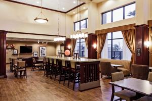 a lobby with a bar and tables and chairs at Hampton Inn & Suites Harlingen in Harlingen