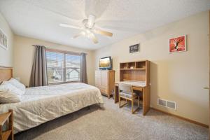 Schlafzimmer mit einem Bett, einem Schreibtisch und einem Fenster in der Unterkunft 2-Bedroom Loft Suite 14 minutes from Airport and Mall of America in Inver Grove Heights