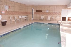 una gran piscina con sillas y mesas en un edificio en Hampton Inn & Suites Hobbs en Hobbs