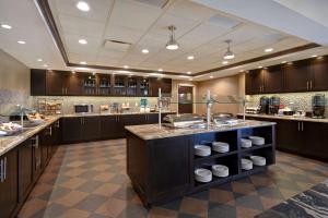 duża kuchnia z drewnianymi szafkami i dużą wyspą w obiekcie Homewood Suites by Hilton Hartford / Southington CT w mieście Southington