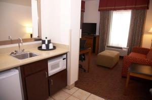 a kitchen with a sink and a living room at Hampton Inn & Suites Hobbs in Hobbs