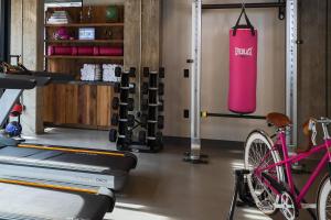 een fitnessruimte met een roze bokszak en een fiets bij Moxy Boulder in Boulder