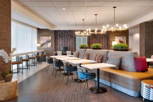 eine Bar mit Tischen und Stühlen in einem Restaurant in der Unterkunft Home2 Suites by Hilton Houston Katy in Katy