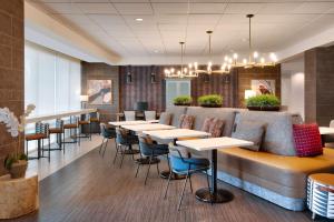 凯蒂Home2 Suites by Hilton Houston Katy的餐厅内带桌椅的酒吧