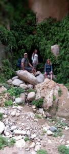 un grupo de personas sentadas en una gran roca en Dana Nabil Ecu Camp House - Main Gate Dana nature reserve en Dana