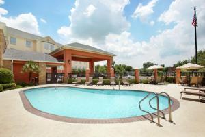 a pool at a hotel with chairs and a building at Homewood Suites by Hilton Houston Stafford Sugar Land in Stafford