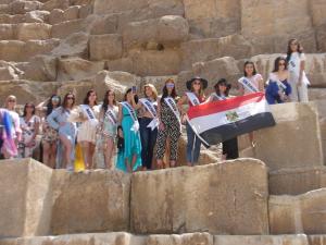 un grupo de mujeres de pie en una pared de piedra con una bandera en Egypt Pyramids Hotel en El Cairo
