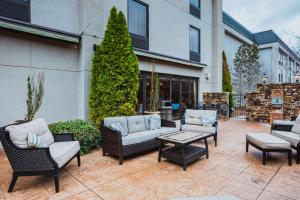 eine Terrasse mit mehreren Stühlen und einem Tisch in der Unterkunft Hampton Inn Huntsville-Madison in Madison