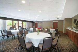 a conference room with a table and chairs and a kitchen at Hampton Inn Huntsville-Madison in Madison