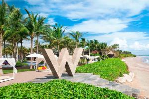 a view of the beach with a large metal sign in front at W Bali - Seminyak in Seminyak