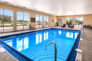 een zwembad in een hotel met tafels en stoelen bij Hampton Inn Derby-Wichita Southeast in Derby