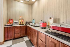 a large kitchen with wooden cabinets and a counter at Hampton Inn Derby-Wichita Southeast in Derby