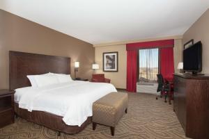 a hotel room with a bed and a flat screen tv at Hampton Inn & Suites I-35/Mulvane in Mulvane