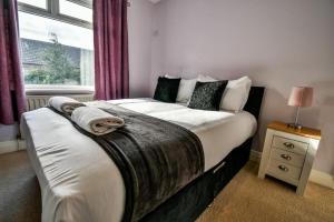1 dormitorio con 1 cama grande y ventana en Buckingham House - 4 Bed House en Redcar