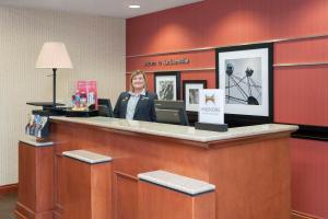 a woman standing behind a counter in a hotel lobby at Hampton Inn Jacksonville in Jacksonville