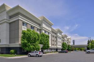 a large building with cars parked in a parking lot at Hampton Inn Idaho Falls / Airport in Idaho Falls