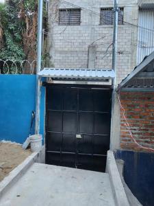 a black garage door on a brick building at Regalo de Dios 