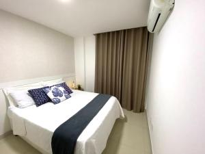 um quarto com uma cama com almofadas azuis em Blue Hope by Mosaico Stays em Vitória
