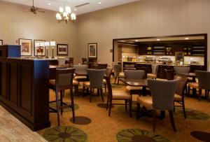 een restaurant met tafels en stoelen en een bar bij Homewood Suites by Hilton Coralville - Iowa River Landing in Coralville