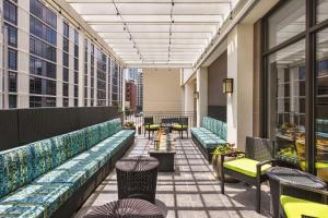 a balcony with benches and tables on a building at Home2 Suites Long Island City/Manhattan View in Queens