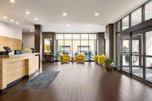 een kantoor met gele stoelen, tafels en ramen bij Home2 Suites Long Island City/Manhattan View in Queens